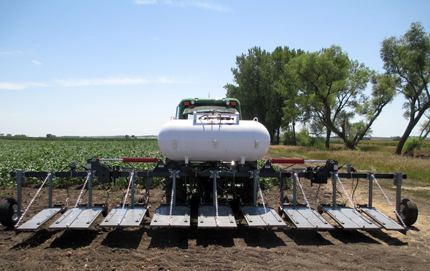 An 8-row flame weeder with shields positioned flat for broadcast flaming at field's edge