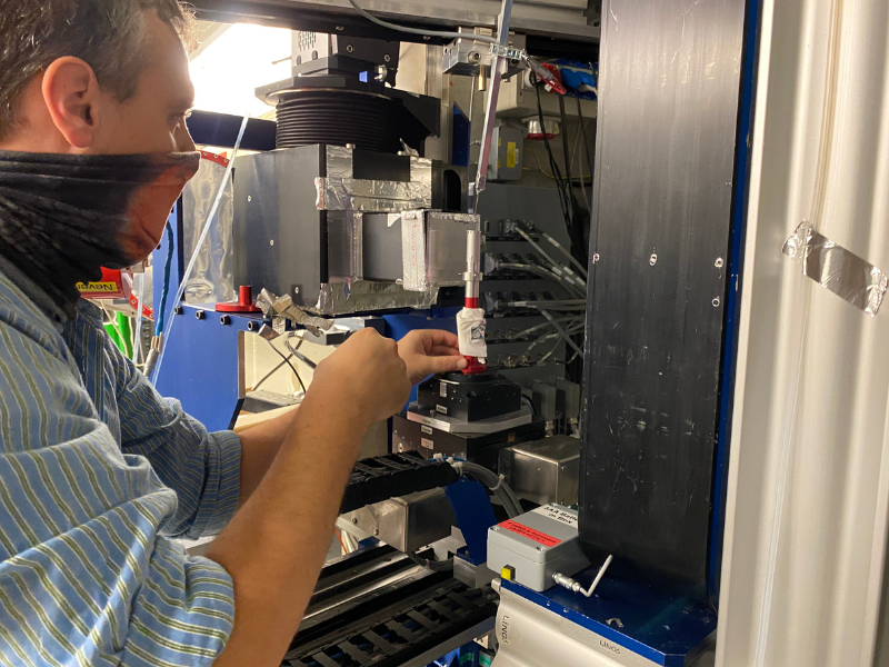 male scientist setting up sample in front of neutron beam