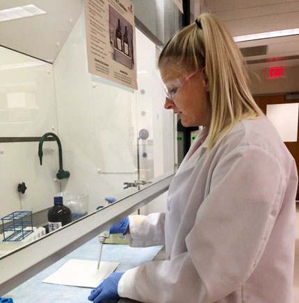 Woman in lab coat working at a lab bench