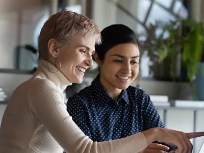 An older woman mentors a younger colleague