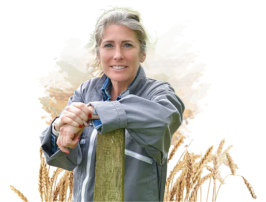 Woman standing with shovel in front of wheat